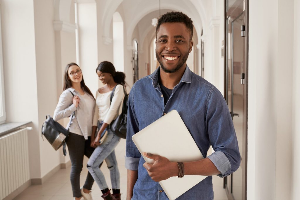 positivity african student wearing shirt holding notes.